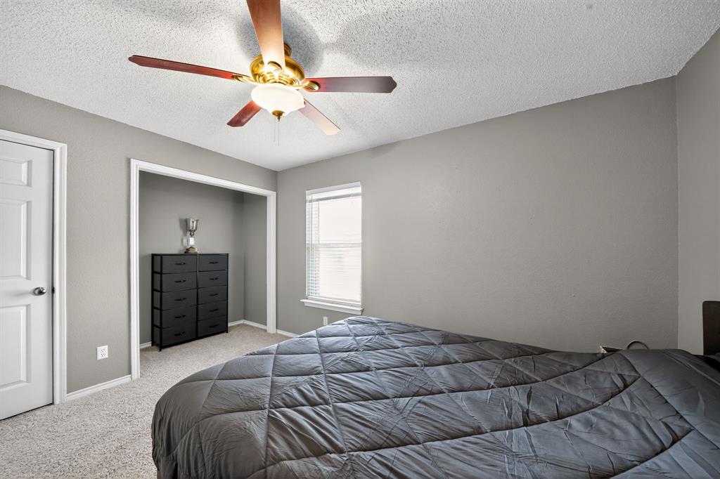 604 McAnear Street Cleburne, TX 76033 - Photo 14 of 18 a bedroom with a large bed and a chandelier fan