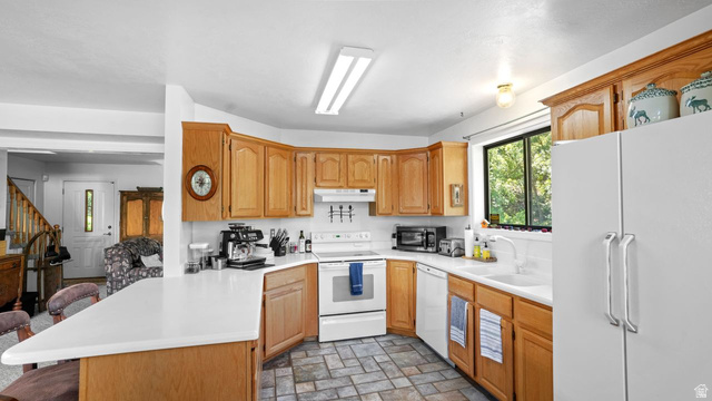 335 Jungfrau Hill Road Midway, UT 84049 - Photo 20 of 34 Kitchen featuring white appliances, a peninsula, light countertops, and a breakfast bar
