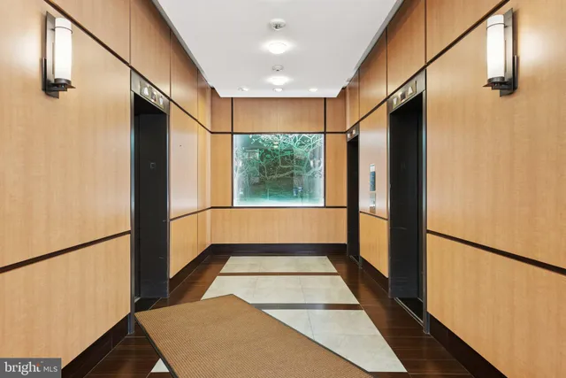 a view of a hallway with wooden floor and a living room
