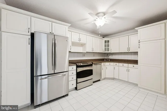 a kitchen with stainless steel appliances white cabinets and a refrigerator