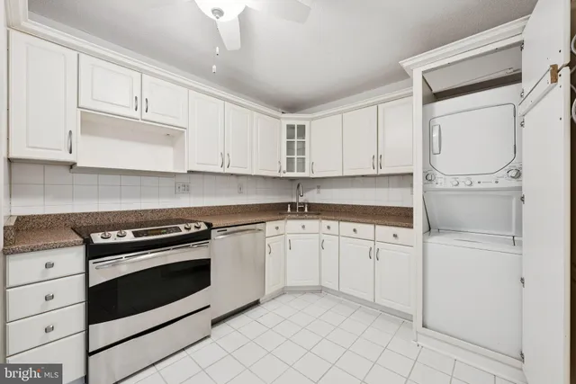 a kitchen with granite countertop white cabinets stainless steel appliances and sink