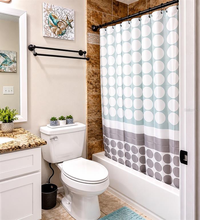 11177 Elgin Boulevard Spring Hill, FL 34608 - Photo 5 of 10 a white toilet sitting next to a shower curtain