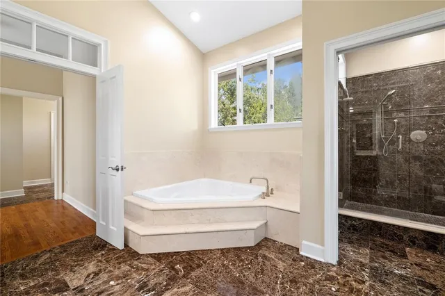 a bathroom with a granite countertop sink mirror and a bathtub