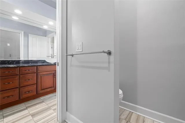a view of a white house with a large tree next to a yard