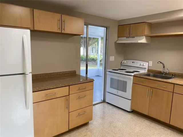 a kitchen with cabinets and white appliances