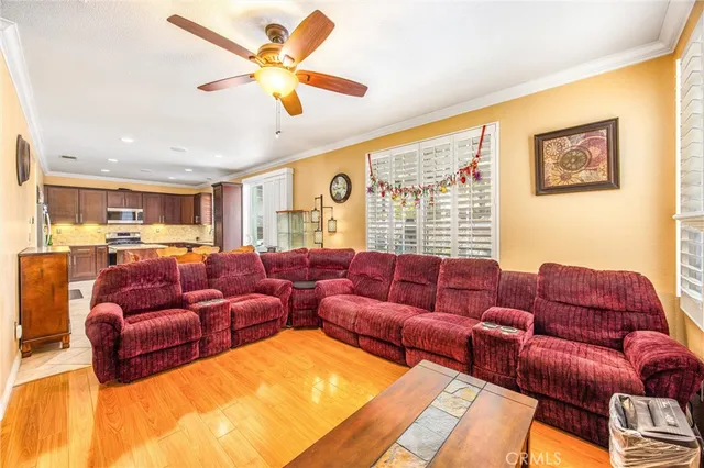 a living room with furniture ceiling fan and a large window