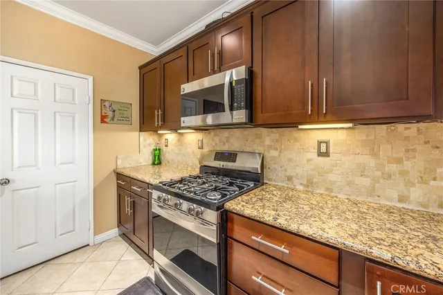 a kitchen with stainless steel appliances granite countertop a stove a sink and a microwave