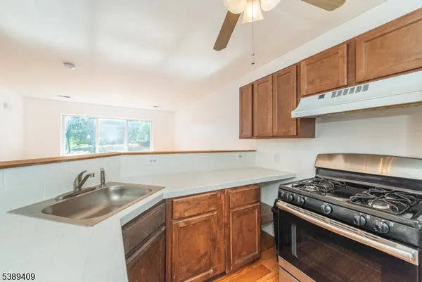 a kitchen with stainless steel appliances granite countertop a sink stove and cabinets