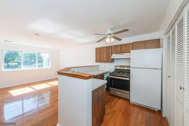 a kitchen with stainless steel appliances granite countertop a refrigerator a stove a sink and a window