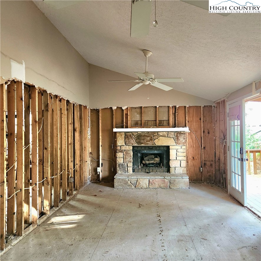 58 River Road Newland, NC 28657 - Photo 12 of 28 an empty room with fireplace chandelier and windows