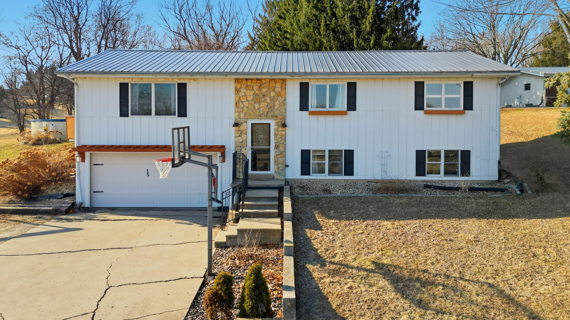 a view of a white house with large windows next to a road