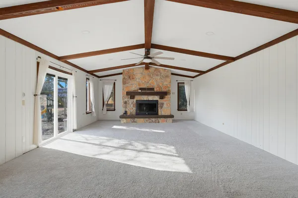 a view of empty room with fireplace and windows