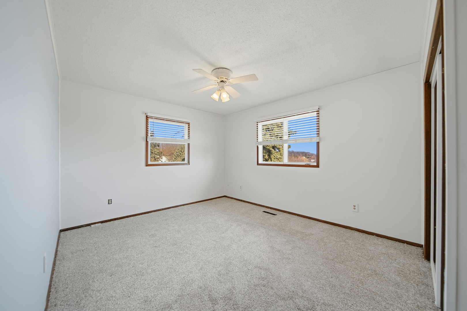 13831 Prairie Center Road Morrison, IL 61270 - Photo 17 of 32 an empty room with windows and a ceiling fan