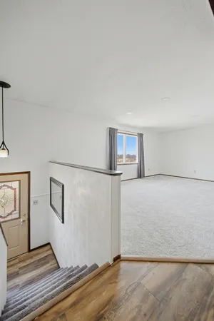 a view of a livingroom with wooden floor and stairs