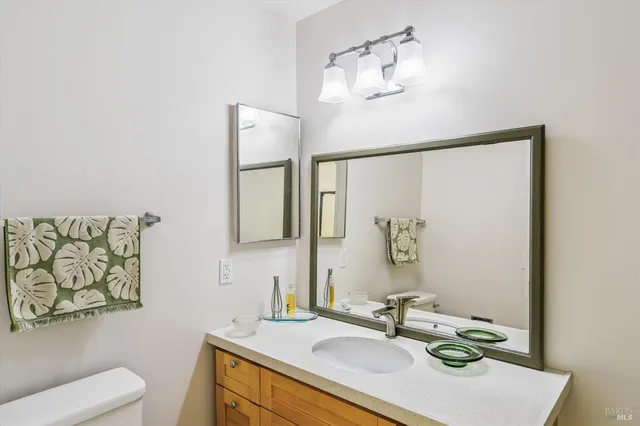 a bathroom with a sink vanity mirror and toilet