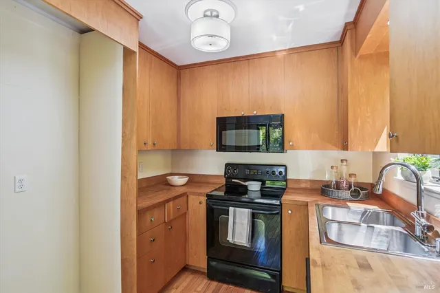 a kitchen with stainless steel appliances a stove microwave and sink