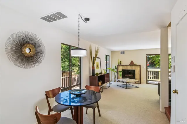 a living room with furniture a fireplace and a floor to ceiling window