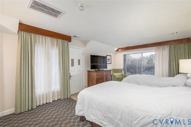 a bedroom with a large bed and a flat screen tv