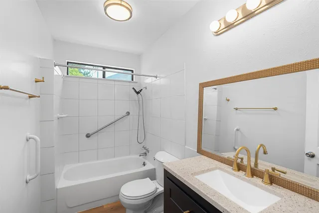 a bathroom with a granite countertop sink toilet and shower