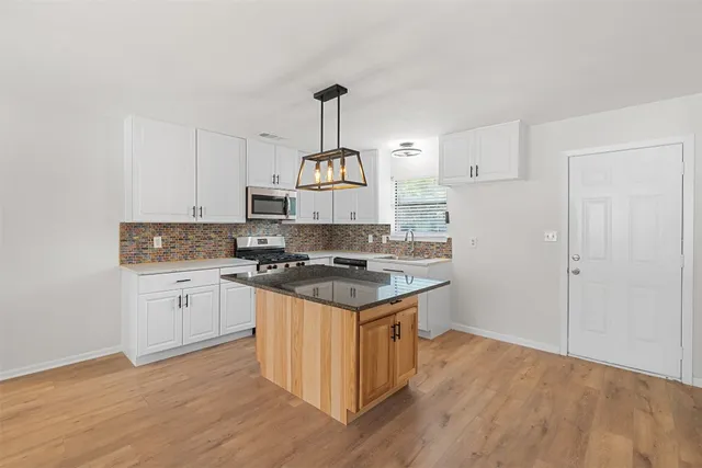 a kitchen with a stove a sink and a refrigerator
