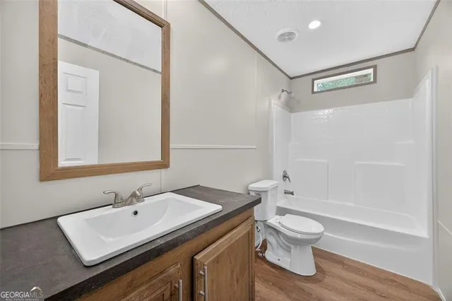 a bathroom with a sink toilet a mirror and shower