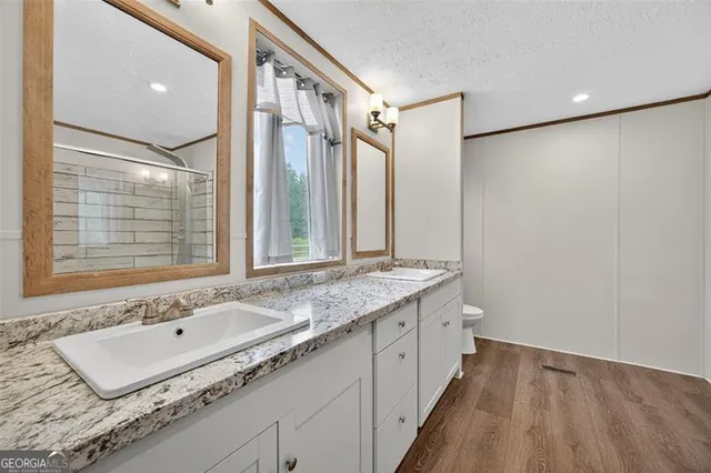 a bathroom with a granite countertop sink mirror and a bathtub