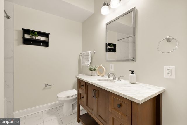 a bathroom with a sink a toilet and mirror