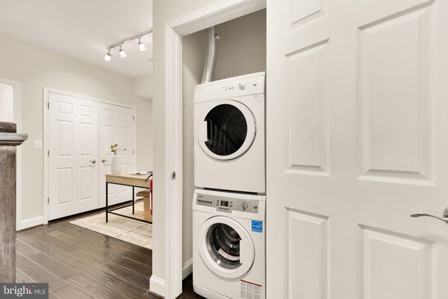 a utility room with dryer washer and a view of bedroom
