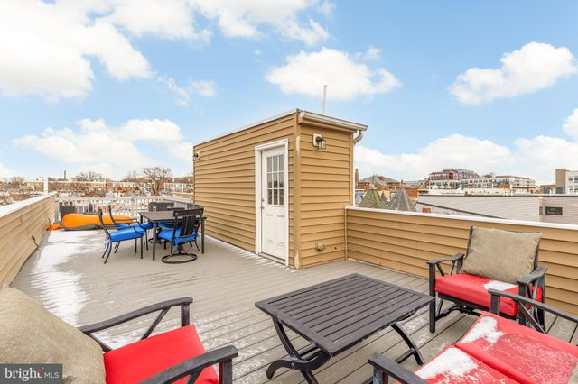 an outdoor sitting area with furniture and city view