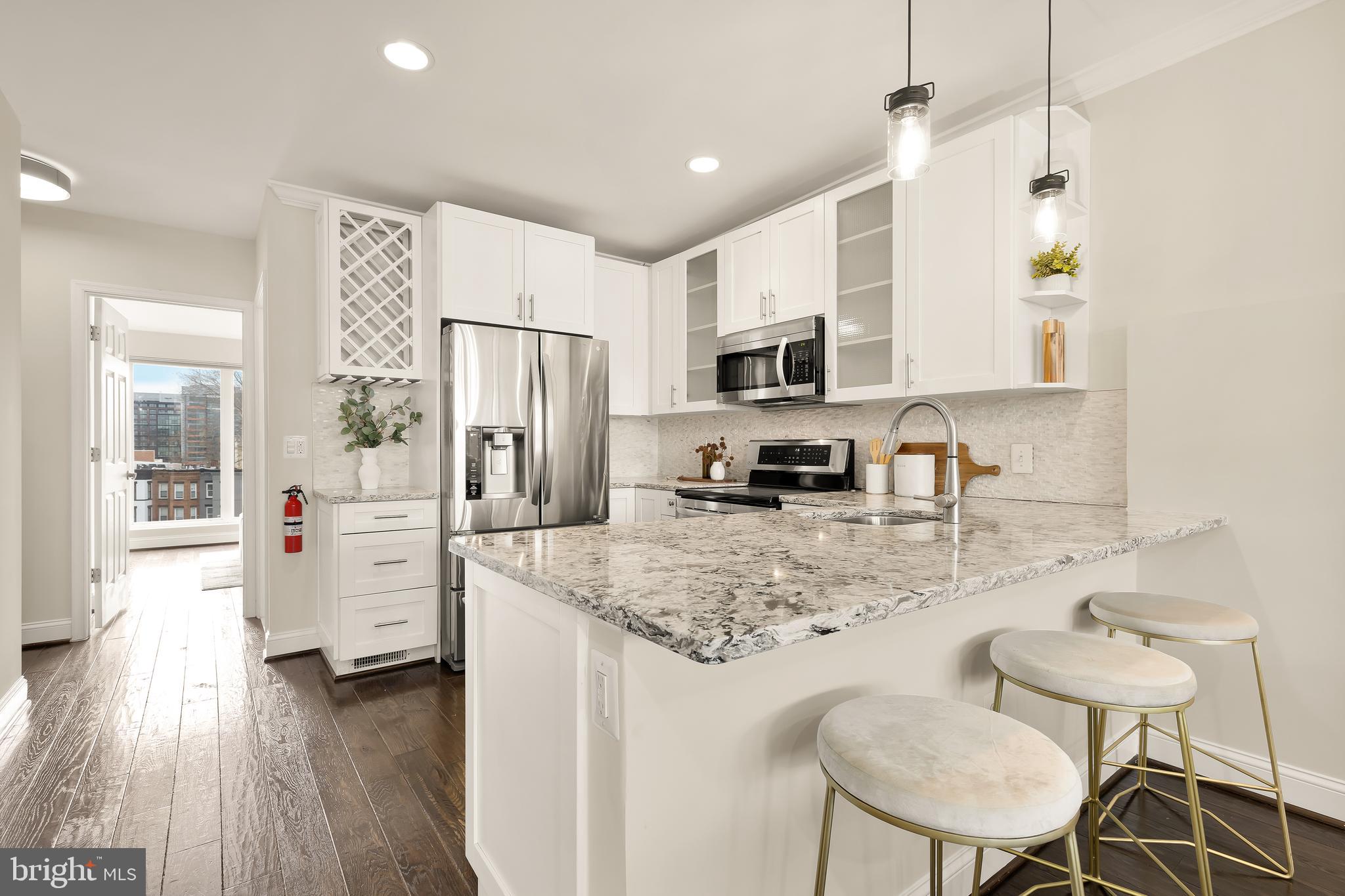 29 Q Street Northeast, Unit 2 Washington, DC 20002 - Photo 2 of 22 a kitchen with refrigerator cabinets and wooden floor