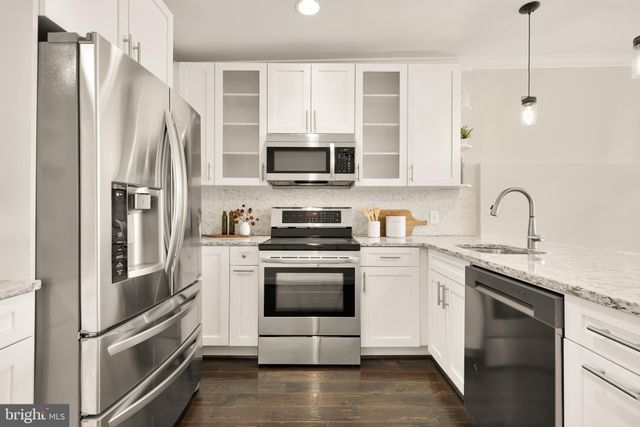 a kitchen with stainless steel appliances a refrigerator sink and microwave