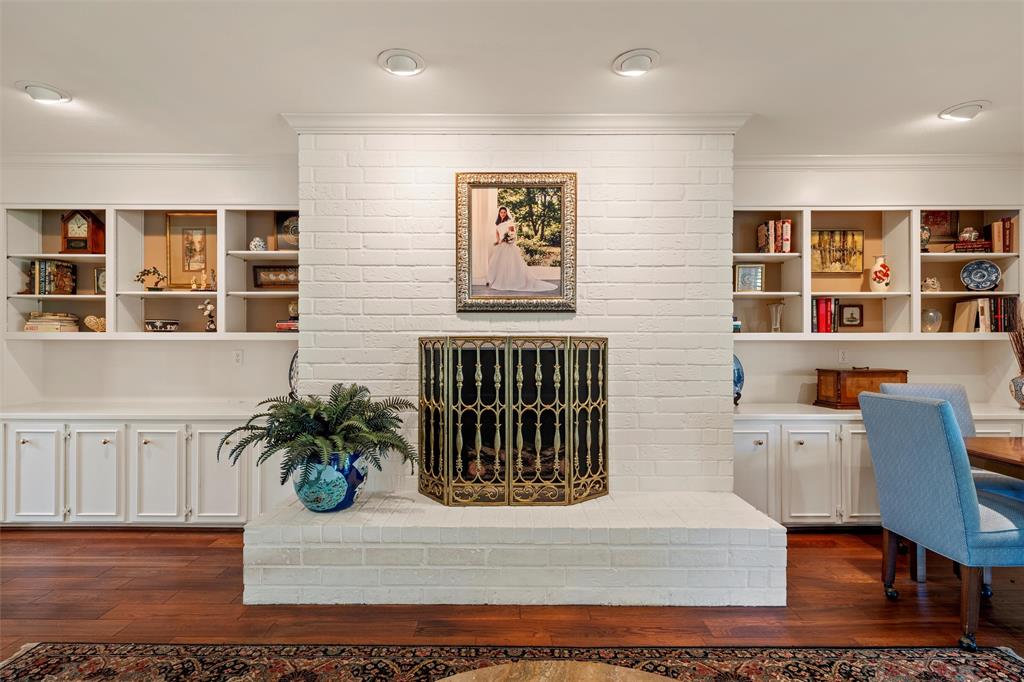 3907 Old Mill Road Waco, TX 76710 - Photo 3 of 30 Living area with crown molding, dark wood-type flooring, and a brick fireplace