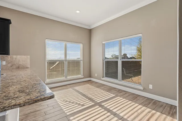 a view of a room with wooden floor and windows