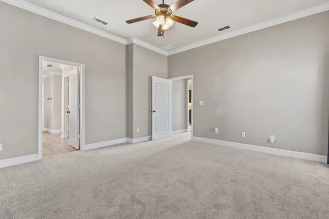 a view of an empty room and chandelier fan