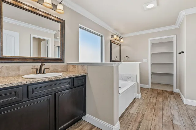a spacious bathroom with a granite countertop sink a toilet and a mirror