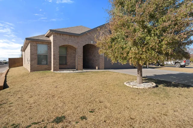 a view of a house with backyard and trees