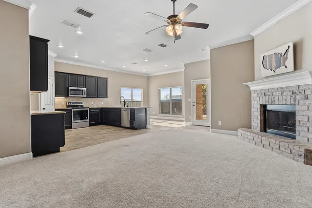 a view of a livingroom with a fireplace a sink and a kitchen counter top space