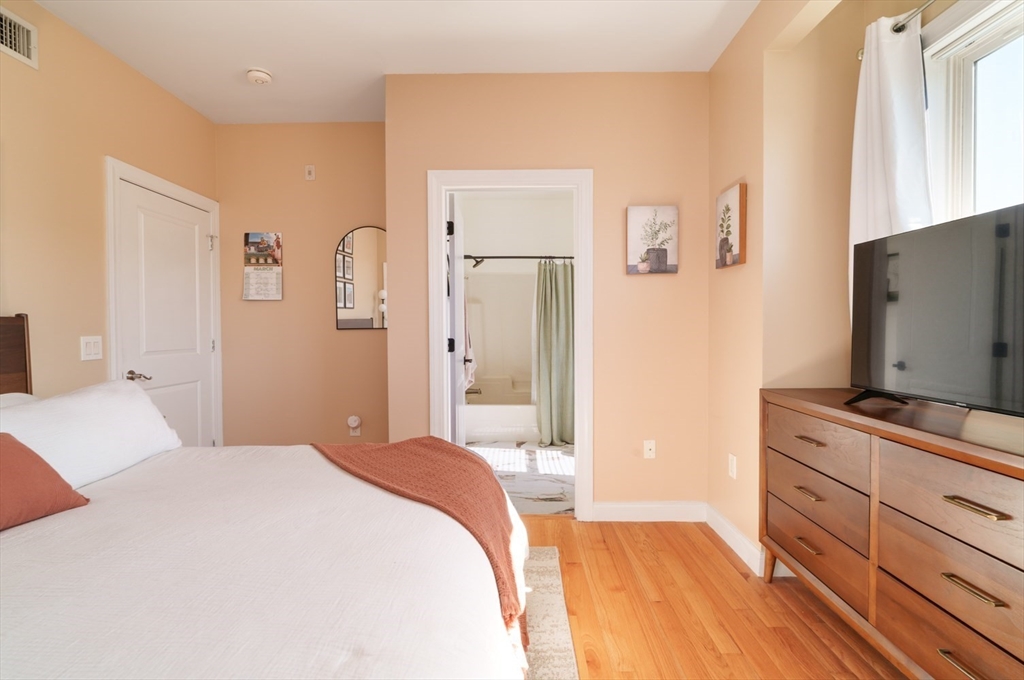 412 Meridian Street, Unit 3 Boston, MA 02128 - Photo 14 of 30 a bedroom with a bed and a flat tv screen on dresser