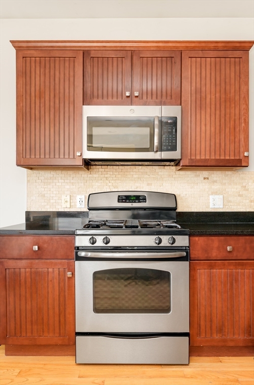 412 Meridian Street, Unit 3 Boston, MA 02128 - Photo 3 of 30 a kitchen with wooden cabinets and a stove top oven