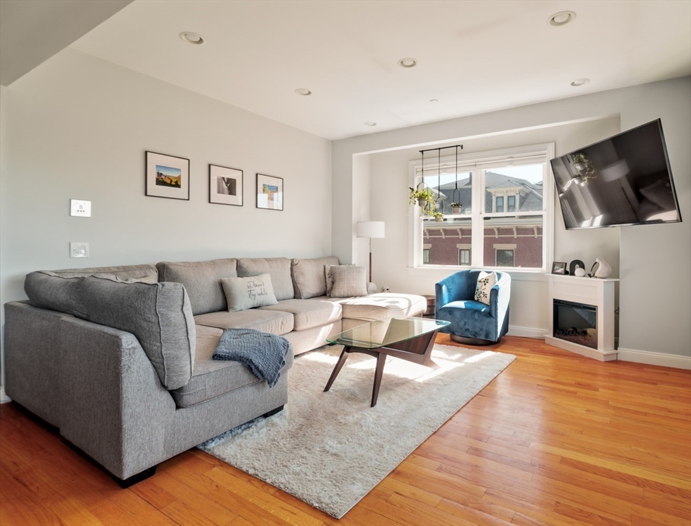 412 Meridian Street, Unit 3 Boston, MA 02128 - Photo 8 of 30 a living room with furniture a flat screen tv and a fireplace