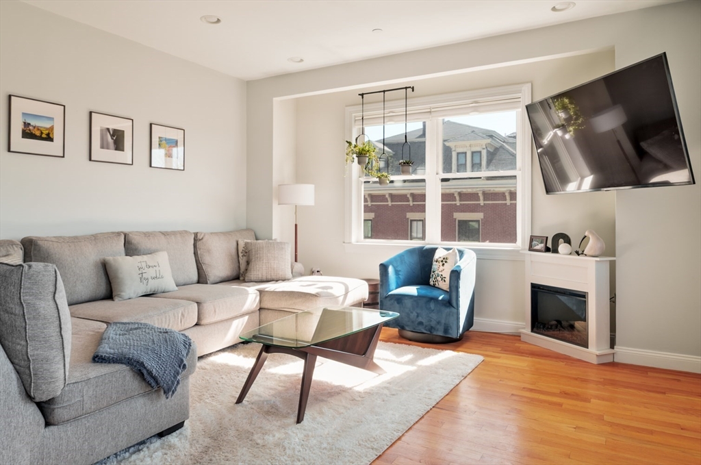 412 Meridian Street, Unit 3 Boston, MA 02128 - Photo 9 of 30 a living room with furniture a flat screen tv and a fireplace