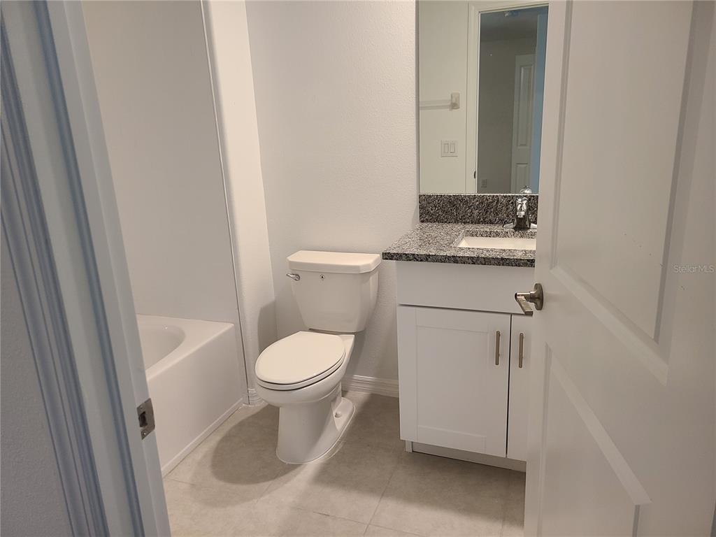 14349 Editors Note Street Ruskin, FL 33573 - Photo 13 of 20 a white toilet sitting next to a bathroom sink