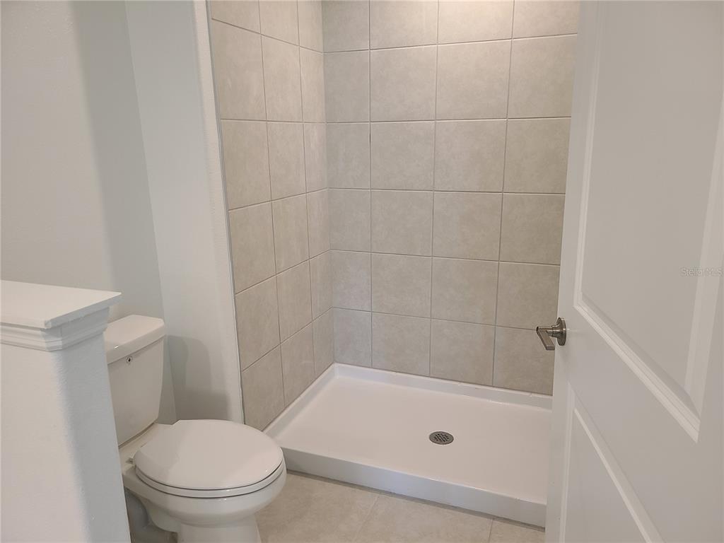 14349 Editors Note Street Ruskin, FL 33573 - Photo 17 of 20 a bathroom with a bathtub and a toilet
