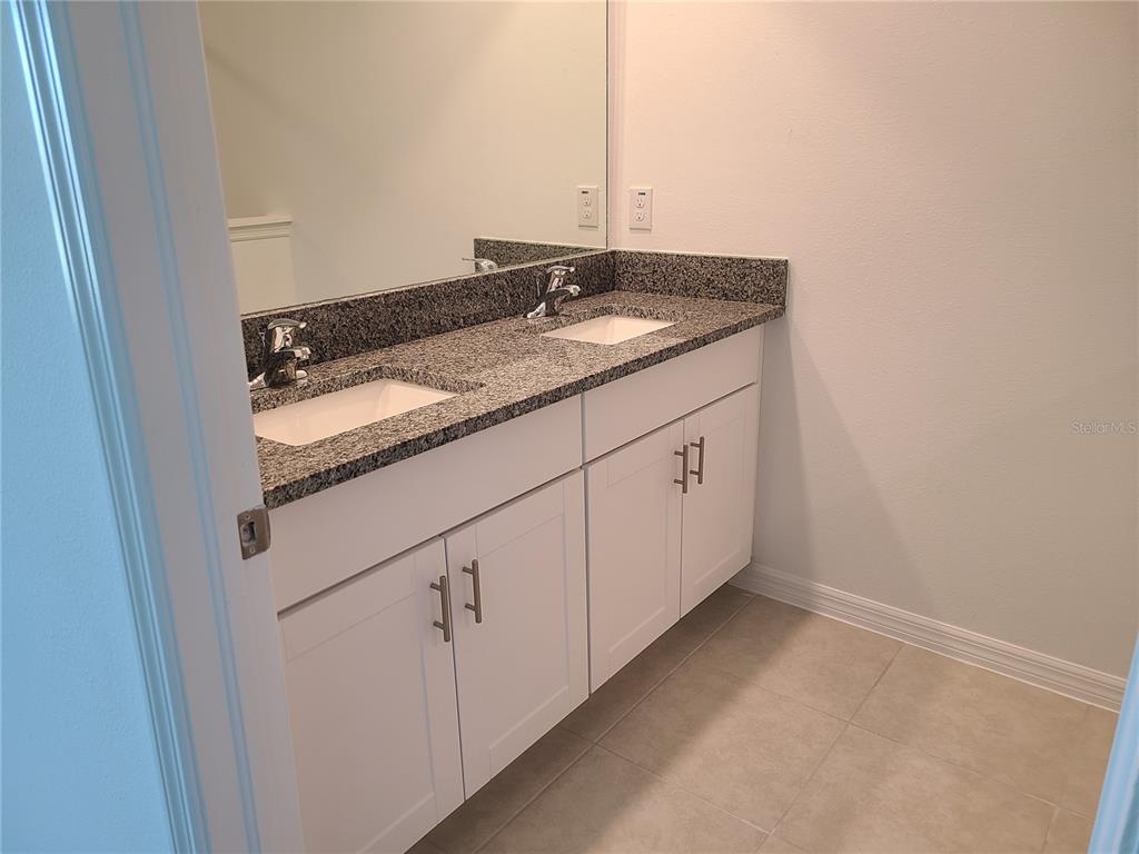 14349 Editors Note Street Ruskin, FL 33573 - Photo 18 of 20 a bathroom with a granite countertop sink and a mirror