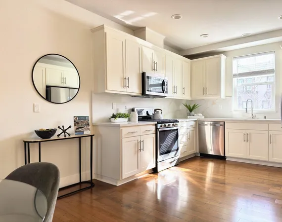 a kitchen with a white cabinets and wooden floor