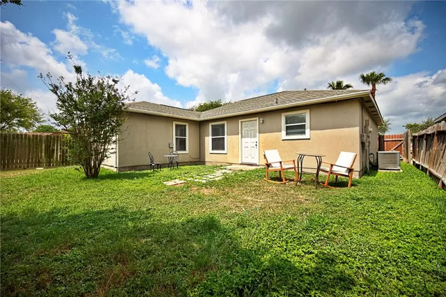 a white house that has a small yard and a trees in it