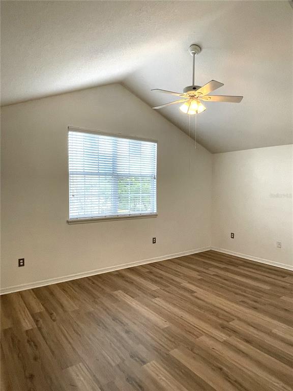 4282 Morton Court Lakeland, FL 33813 - Photo 25 of 72 an empty room with wooden floor chandelier and windows