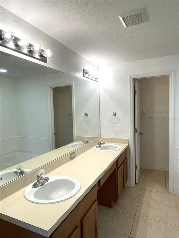 4282 Morton Court Lakeland, FL 33813 - Photo 31 of 72 a bathroom with a granite countertop sink a large mirror and a shower