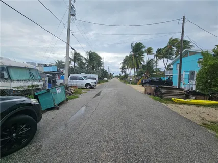 a view of a street with potted plants