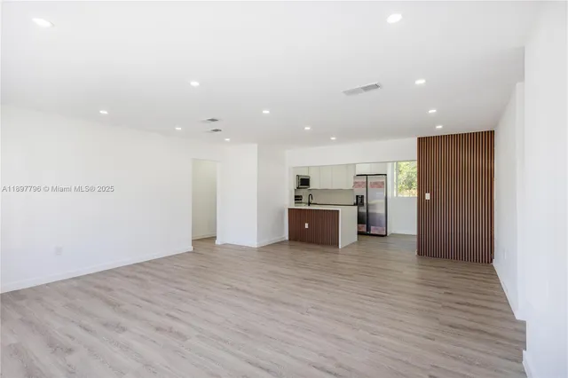 a view of kitchen and kitchen with stainless steel appliances wooden floor